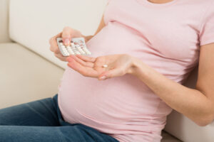 Pregnant woman taking medication.
